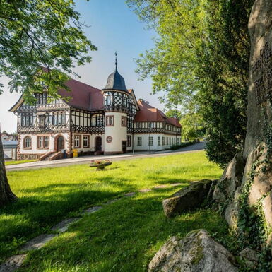 Landschaftsaufnahme mit Historischer Post und Kriegerdenkmal im Vordergrund