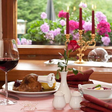 Gedeckter Tisch im Waldhotel Rennsteighof mit Rotwein, Gänsekeule und Thüringer Klößen