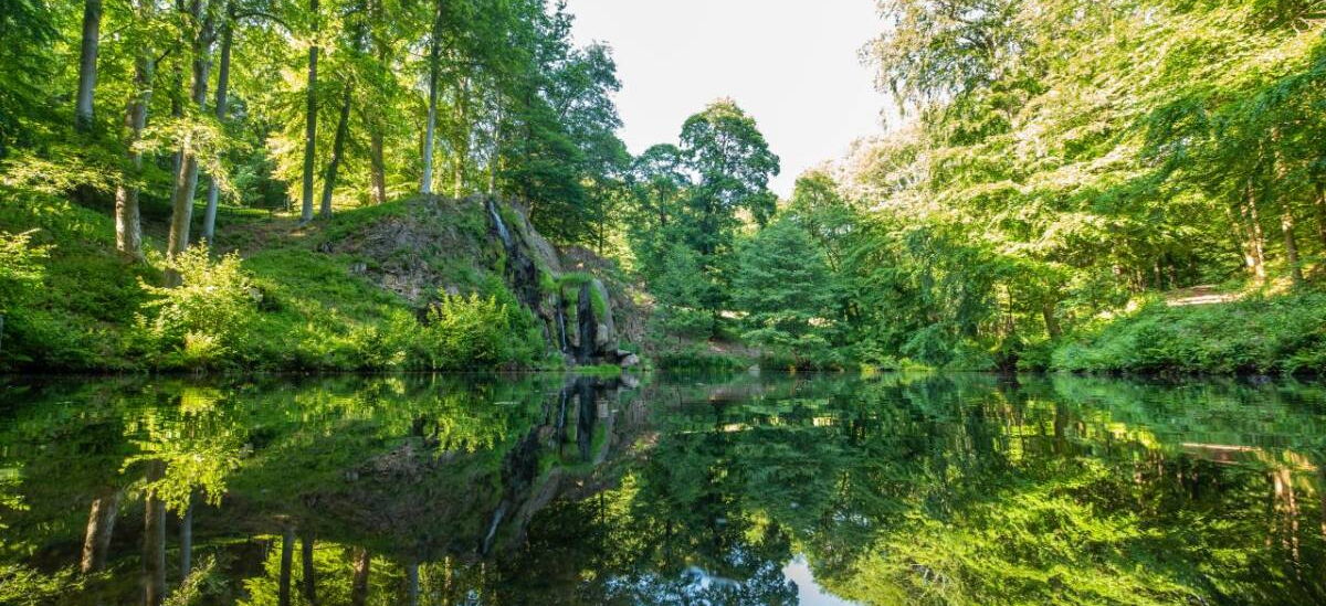 Landschaftsaufnahme mit Luisenthaler Wasserfall und Teich im Schlosspark Altenstein