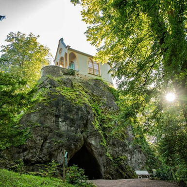 Landschaftsaufnahme Felsen mit Treppen und Höhle, darauf Ritterkapelle im Schlosspark Altenstein