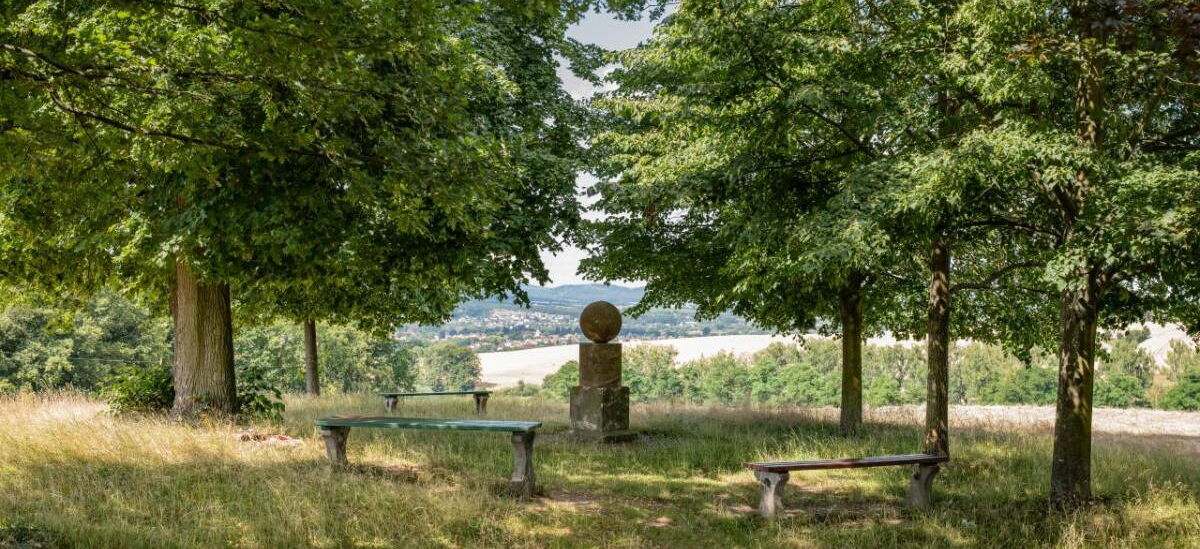 Landschaftsaufnahme mit Fröbelsruh, ursprünglichem Grabstein Fröbels, Sitzbänken und Blick ins Werratal