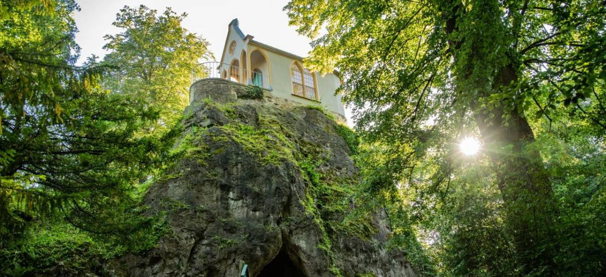Landschaftsaufnahme Felsen mit Treppen und Höhle, darauf Ritterkapelle im Schlosspark Altenstein